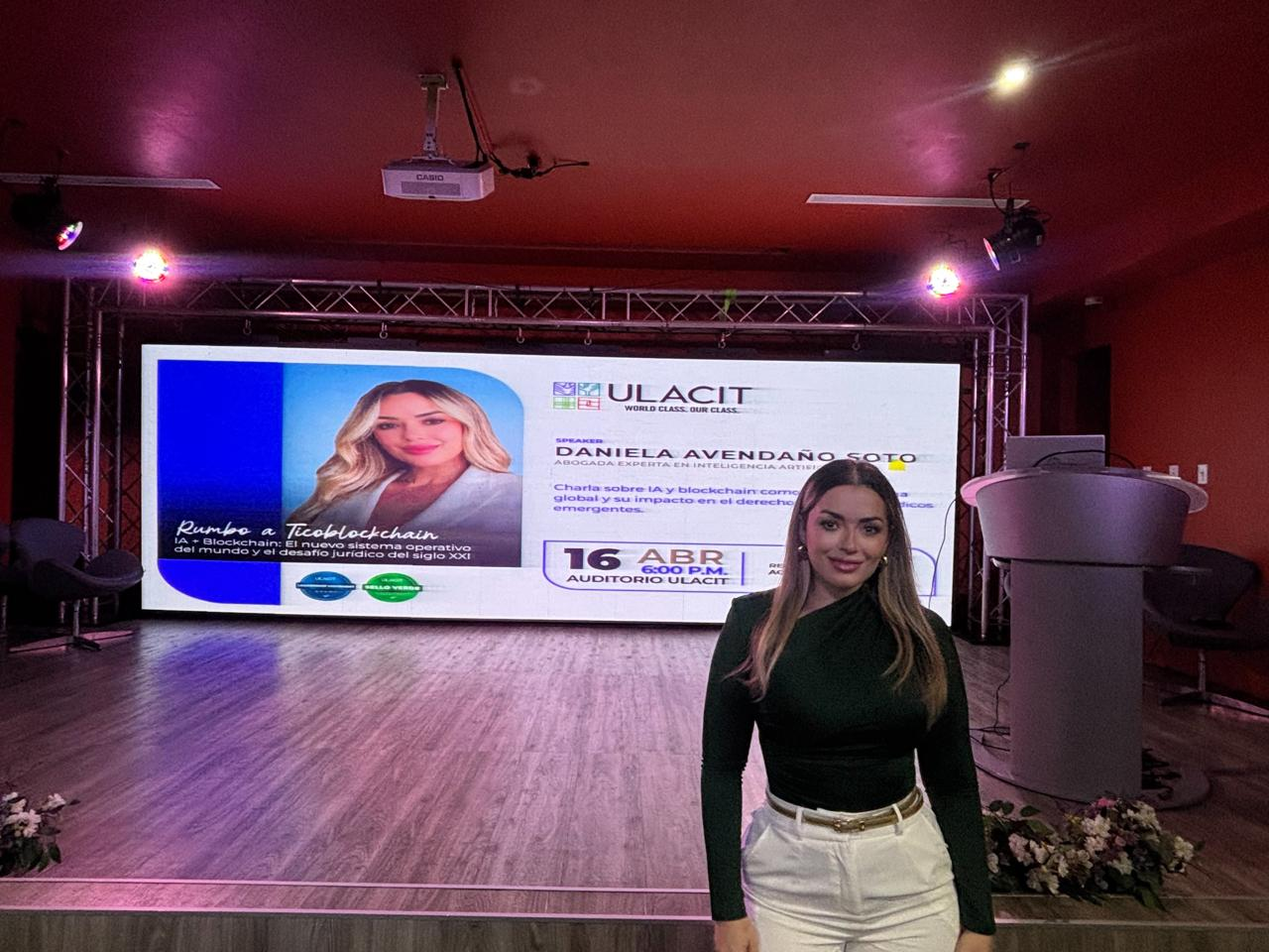 Licda. Daniela Avendaño frente a la pantalla del evento en el auditorio de ULACIT.